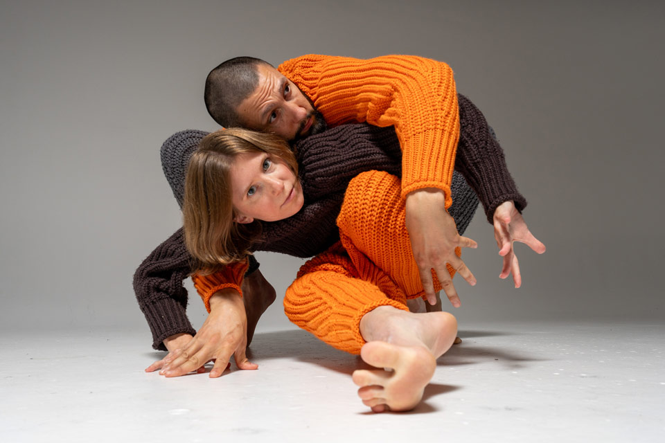 push/FOLD dancers Briley Jozwiak and Samuel Hobbs pose overly large sweaters in an entangled standing pose at Cobalt Studios in Portland, Oregon | Photography: Eric Raeber