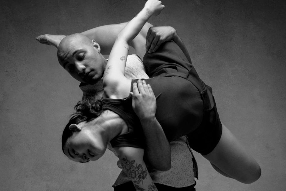 The dancers of LITVAK Dance of San Diego partnering in a black and white photo with one dancer lifting another.