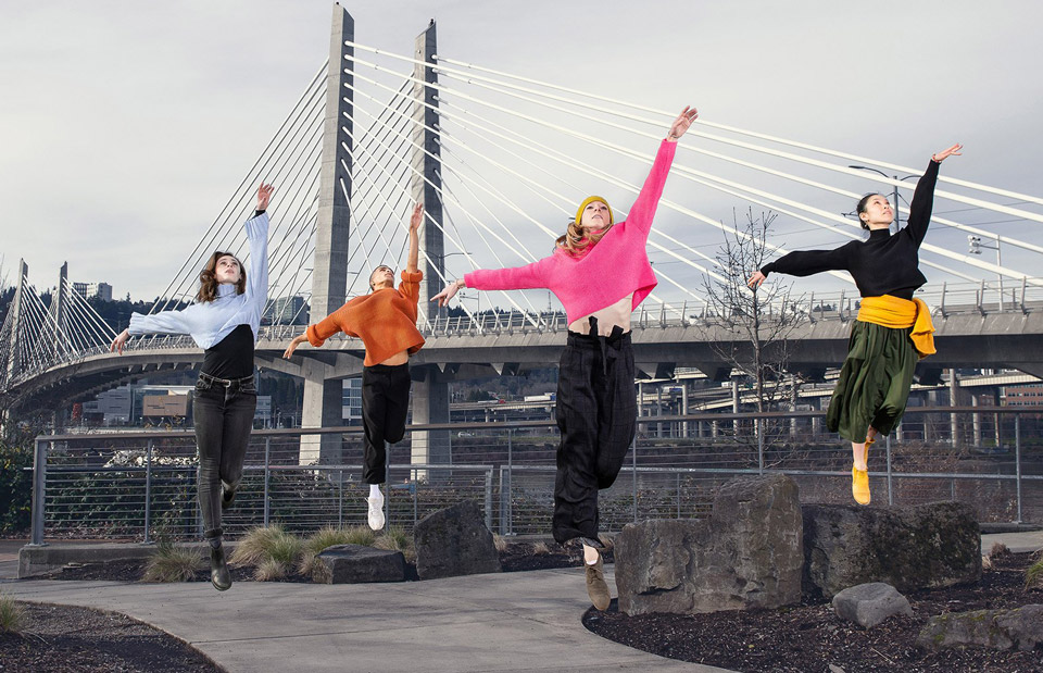 Oregon Ballet Theatre dancers jumping in the air with Portland's Tillikum bridge in the background.